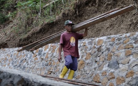 Rusmaji Tetap Memanggul Papan Demi Jalan Impian Desa